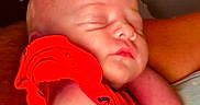Fallon joined the competition — help win amazing prizes! baby, sleeping, infant, red_clothing, arm, close_up, peaceful, skin, portrait, child, resting, indoors, person, sleep, newborn, cute, calm, human, baby_garment, toddler