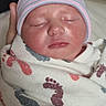 Avery is registered to the contest to win money with this photo: newborn, baby, sleeping, infant, portrait, face, hat, striped_hat, blanket, swaddled, indoors, adult_hand, peaceful, closed_eyes, nose, mouth, textile, patterned_blanket, close_up, family