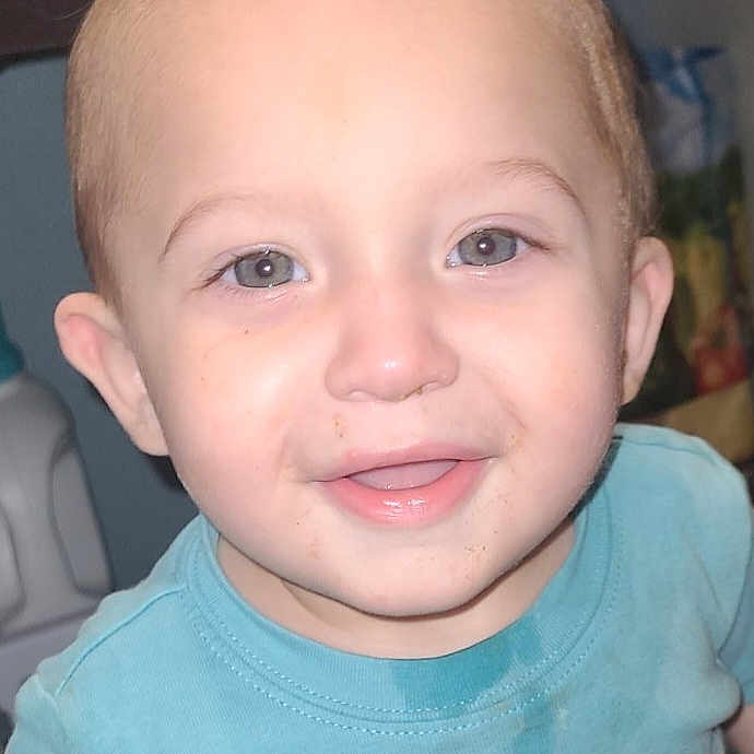 Avery joined the competition — help win amazing prizes! toddler, child, baby, portrait, close_up, smiling, happy, face, blue_eyes, short_hair, light_hair, tongue, t_shirt, blue_shirt, palm_trees, indoor, seated, flash_photography, family_photo, cute