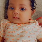 Sadie joined the competition — help win amazing prizes! baby, infant, curly_hair, onesie, text_print, face, portrait, close_up, cute, child, indoors, soft_lighting, looking_at_camera, expression, skin, head, person, newborn, lying_down, cozy
