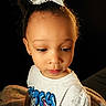 Octavia joined the competition — help win amazing prizes! bow, brown_hair, child, close_up, colorful_clothing, curly_hair, dark_background, expression, eyes, face, girl, hair_bow, indoors, looking_down, portrait, pouting, shirt, sitting, smiling, toddler