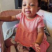 Olivia joined the competition — help win amazing prizes! baby, blanket, candid, child, coral_outfit, curly_hair, furniture, happy, home, indoor, infant, playpen, playtime, plush_toy, portrait, sitting, smiling, striped_clothing, stuffed_toy, water_dispenser
