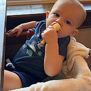 Elijah is registered to the contest to win money with this photo: toddler, child, snack, blanket, chair, window, indoor, cute, baby, relaxed, cozy, eating, curious, portrait, casual, clothing, soft, light, furniture, home