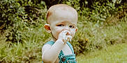 Elijah is registered to the contest to win money with this photo: toddler, child, denim_overalls, cake, outdoor, greenery, grass, sign, happy_camper, birthday, food, frosting, table, celebration, summer, nature, cute, portrait, person, baby