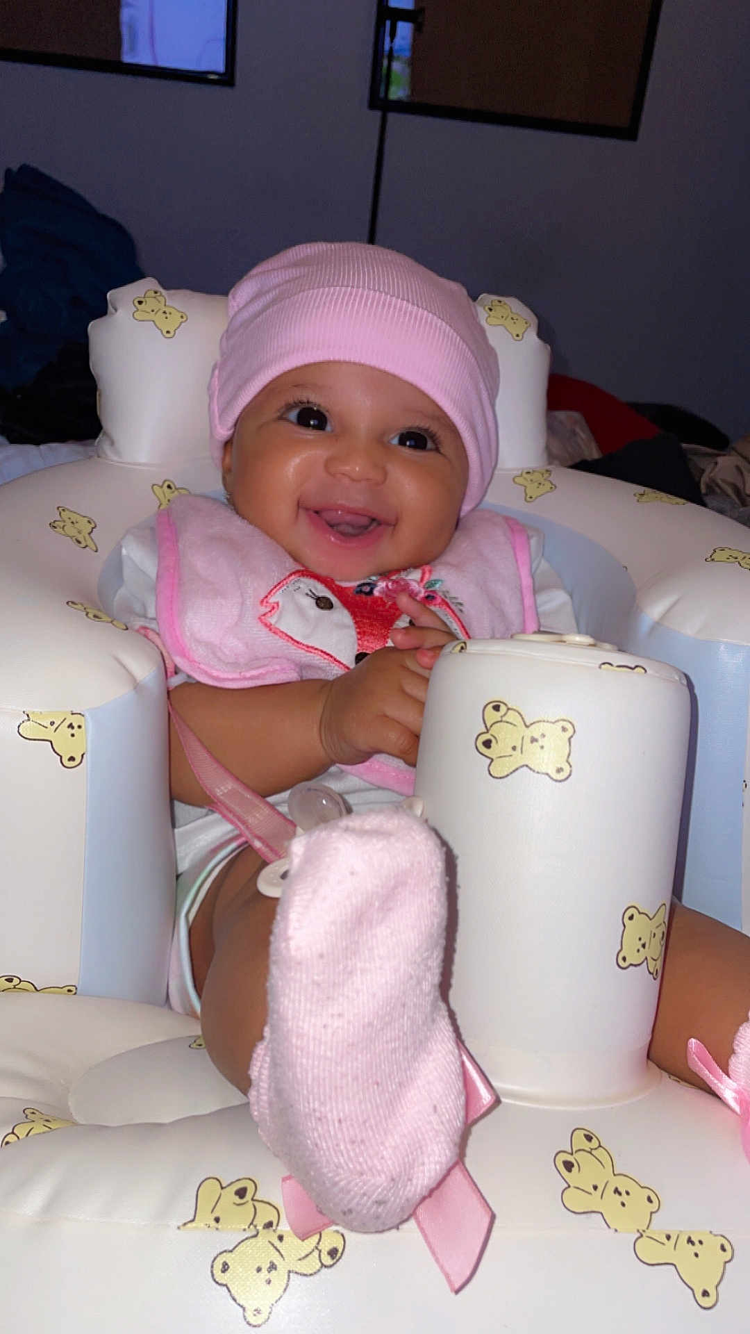 Xylie joined the competition — help win amazing prizes! baby, pink_hat, pink_bib, smiling, inflatable_seat, teddy_bear_pattern, sock, cute, happy, child, indoor, infant, seat, footwear, portrait, playful, childhood, baby_girl, soft_lighting, closeup