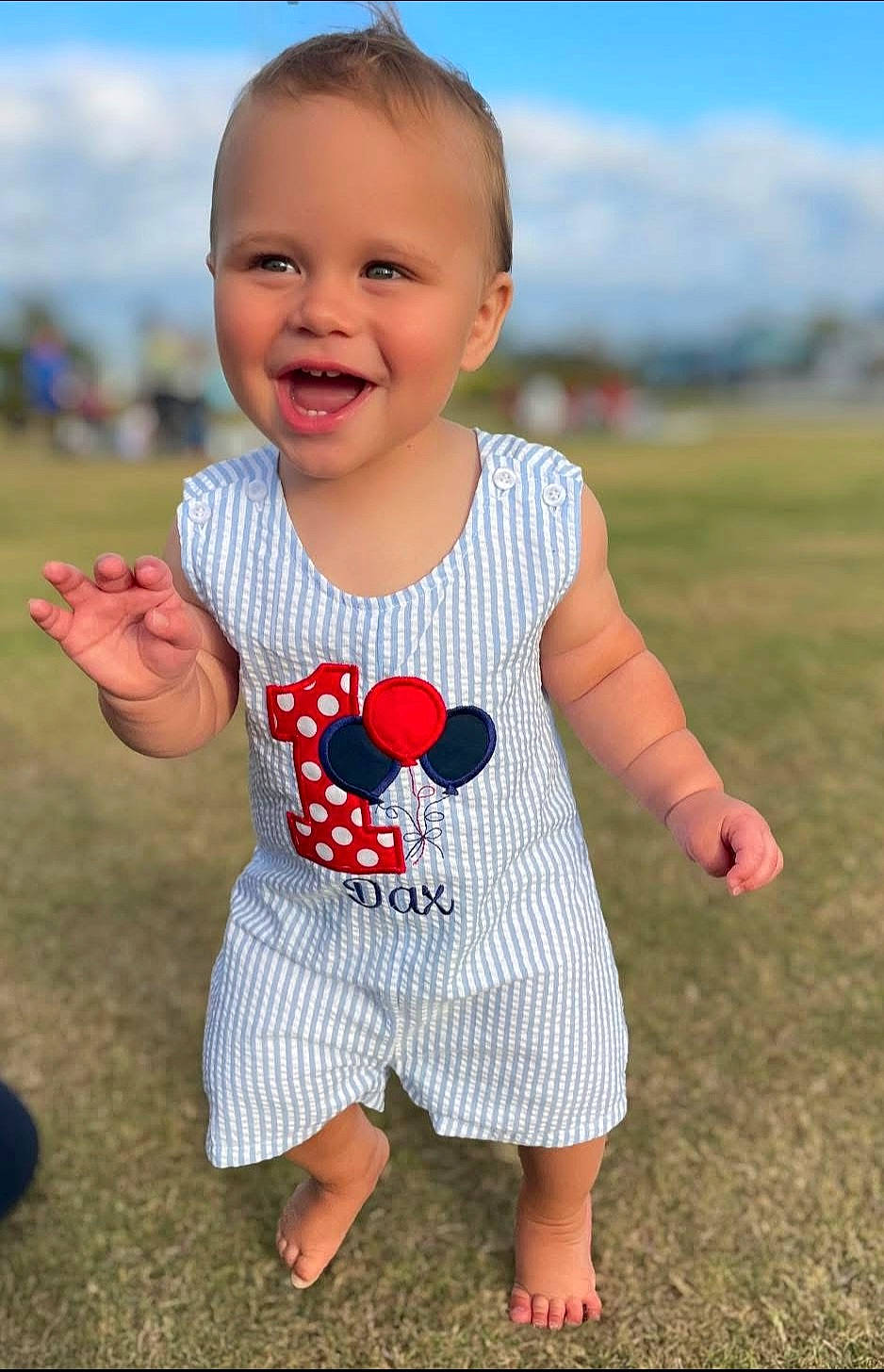 Dax joined the competition — help win amazing prizes! balloons, barefoot, birthday, blue_sky, celebration, child, clothing, cute, daytime, grass, happy, number_one, outdoor, portrait, romper, smiling, sunny, toddler, walking, young_child