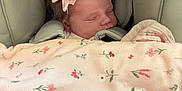 Lottie-Lil is registered to the contest to win money with this photo: baby, sleeping, car_seat, pink_bow, blanket, floral_pattern, infant, child, cute, peaceful, soft, head, face, hair, indoors, safety, rest, comfort, newborn, bundle
