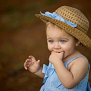 Charleigh joined the competition — help win amazing prizes! toddler, child, blue_eyes, straw_hat, blue_dress, cute, portrait, outdoor, baby, hand, fingers, earrings, summer_hat, expression, person, young_child, nature, soft_background, closeup, innocence