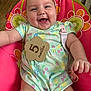 Daisy joined the competition — help win amazing prizes! baby, infant, smiling, happy, sitting, onesie, floral_pattern, pink_baby_seat, wooden_sign, 5_months, pacifier, arm, hand, face, cute, indoors, floor, wooden_floor, child, person