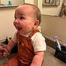 Andre joined the competition — help win amazing prizes! baby, child, smiling, overalls, bathroom, mirror, toothbrush, countertop, tattoo, holding_hands, cute, happy, infant, person, short_sleeve, orange_clothing, reflection, sink, pottery, indoor