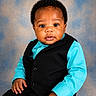 Messiah joined the competition — help win amazing prizes! baby, infant, child, portrait, studio, clothing, vest, shirt, black, turquoise, face, hands, curly_hair, sitting, cute, expression, background, photography, person, eyes