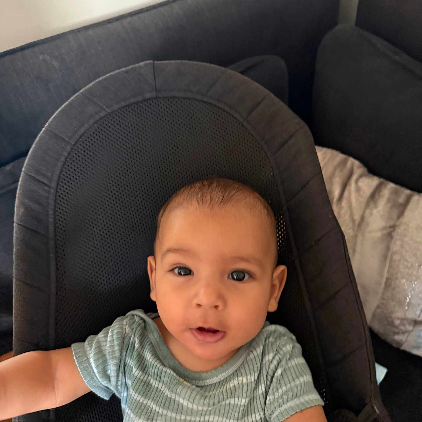 Kamil a rejoint le concours — aidez-le/la à gagner de superbes lots ! arm, baby, babybjorn, black, child, clothing, couch, curious, cushion, expression, eyes, face, indoors, infant, mouth, portrait, seat, soft_furniture, striped_shirt, young_child