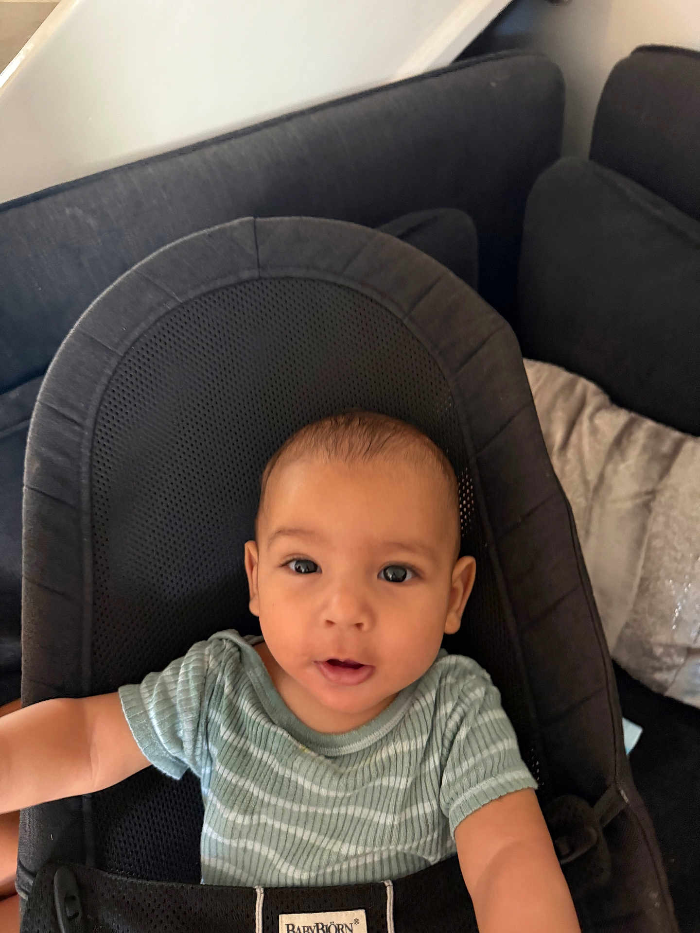 Kamil a rejoint le concours — aidez-le/la à gagner de superbes lots ! baby, infant, child, face, eyes, mouth, expression, seat, babybjorn, clothing, striped_shirt, arm, indoors, couch, cushion, black, soft_furniture, portrait, curious, young_child