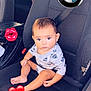 baby, child, car_seat, seatbelt, worn_seat, digital_stickers, heart_emoji, lips_emoji, bmw_logo, infant, clothing, sitting, indoors, cute, expressionless, car_interior, person, young_child, casual, portrait