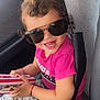 Antonia participe au concours pour gagner de l'argent avec cette photo : toddler, child, sunglasses, pink_shirt, car_seat, seatbelt, curly_hair, smile, happy, toy_box, casual_clothing, indoor, vehicle_interior, playful, cute, small_person, seated, holding_object, light, portrait