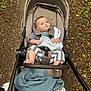 baby, stroller, blanket, outdoor, forest_path, leaves, autumn, child, curious, clothing, footwear, nature, walking, person, seat, fabric, soft_toy, foot, hand, daylight