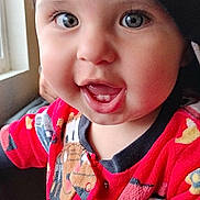 Fabian joined the competition — help win amazing prizes! baby, toddler, child, smiling, face, cap, hat, red_clothing, onesie, indoor, window, person, cute, happy, portrait, headwear, young_child, colorful, playful, closeup