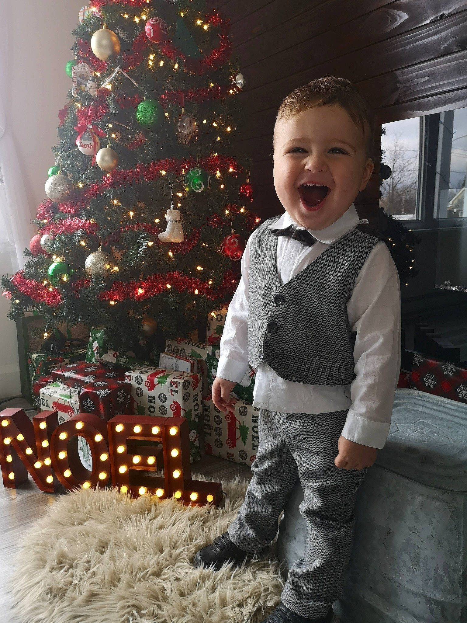 Jacob participe au concours pour gagner de l'argent avec cette photo : baby_toddler_clothing, christmas_decoration, christmas_eve, christmas_ornament, christmas_tree, event, evergreen, fun, happy, holiday, holiday_ornament, human_body, ornament, person, plant, sleeve, smile, snapshot, standing, toddler