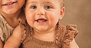 Nevaeh is registered to the contest to win money with this photo: child, children, baby, toddler, curly_hair, brown_dress, smiling, hugging, portrait, cute, happy, sibling, family, studio, warm_tones, indoor, skin, face, head, eyes