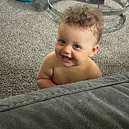Nevaeh joined the competition — help win amazing prizes! toddler, child, smiling, curly_hair, carpet, couch, living_room, glass_table, blue_cushion, happy, indoor, person, baby, home, floor, furniture, cute, playful, young_child, peek