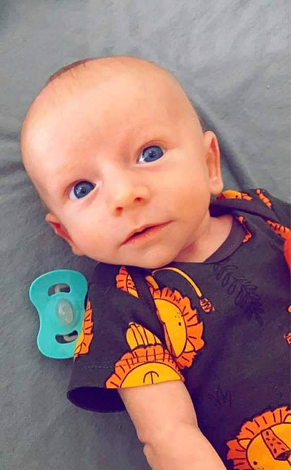 Colton is registered to the contest to win money with this photo: arm, baby, baby_toddler_clothing, cheek, chin, eye, eyebrow, facial_expression, hairstyle, happy, head, human_body, iris, mouth, neck, nose, orange, person, product, skin