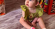 Maisey is registered to the contest to win money with this photo: baby, child, clothing, colorful, curious, cute, expression, floor, furniture, headband, home, indoor, person, playroom, sitting, socks, toddler, toy, wood_floor, young_child