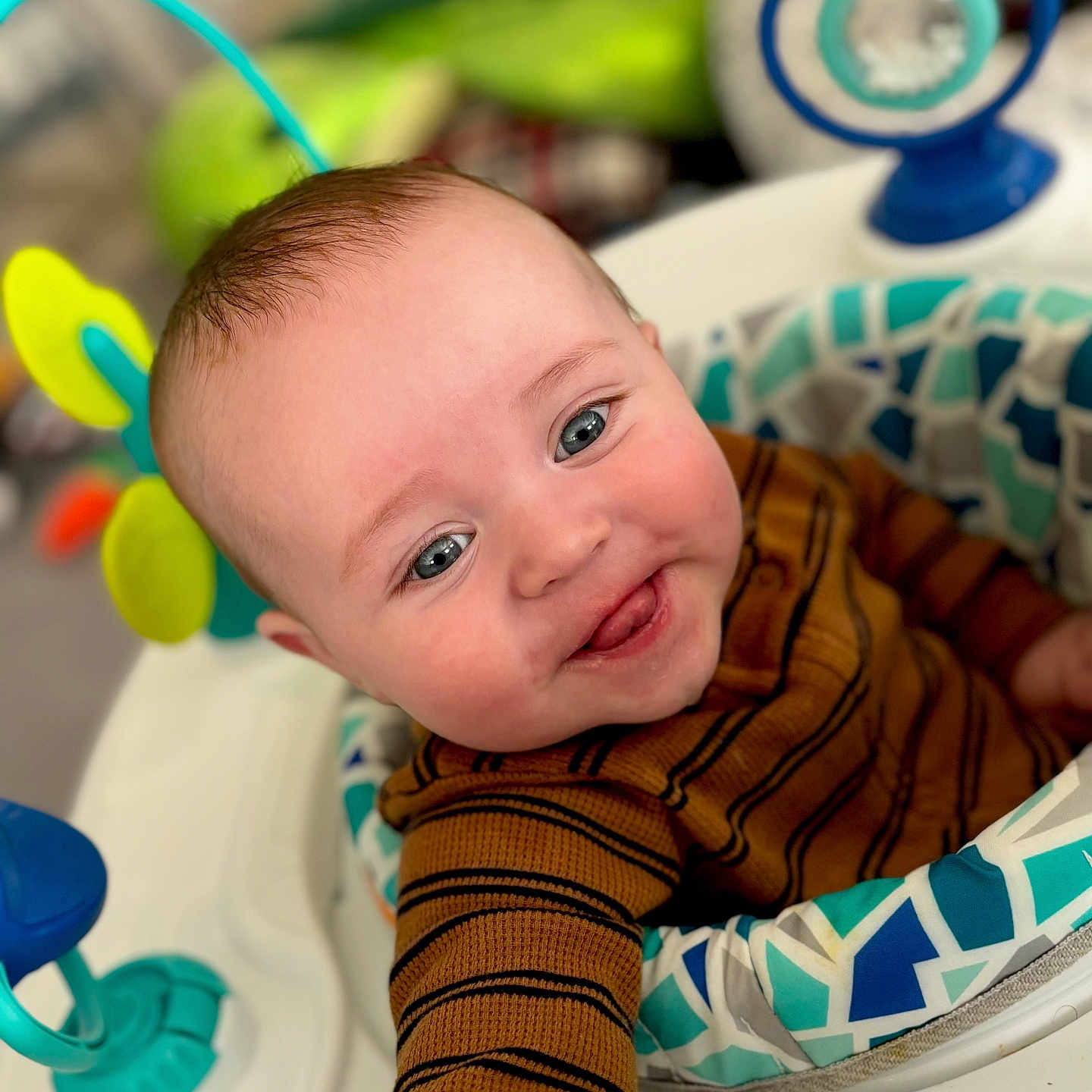 Wylon is registered to the contest to win money with this photo: baby, baby_seat, blue_eyes, cheerful, child, close_up, colorful, cute, face, happy, indoors, infant, person, playful, seated, smiling, striped_sweater, toy, warm_clothing, young_child