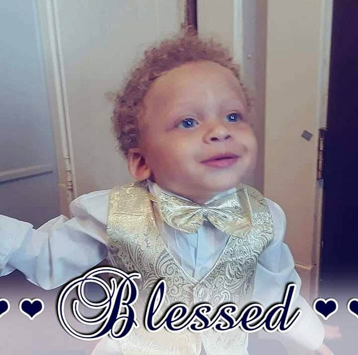 King is registered to the contest to win money with this photo: baby, bow_tie, cheek, child, cool, face, facial_expression, forehead, formal_wear, hair, head, nose, outerwear, person, photo_caption, photography, smile, suit, tie, toddler