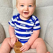 Benson is registered to the contest to win money with this photo: baby, child, blue_eyes, smiling, onesie, striped_clothing, sitting, plaque, wooden_plaque, milestone, indoor, soft_texture, cozy, happy, portrait, cute, chubby_arms, chubby_legs, face, hands