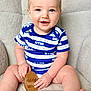 baby, child, blue_eyes, smiling, onesie, striped_clothing, sitting, plaque, wooden_plaque, milestone, indoor, soft_texture, cozy, happy, portrait, cute, chubby_arms, chubby_legs, face, hands