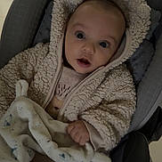 Keylonn participe au concours pour gagner de l'argent avec cette photo : baby, child, infant, car_seat, blanket, plush_toy, clothing, hooded_jacket, hand, face, wide_eyes, indoor, floor, tile_floor, comfort, warm_clothing, expression, seated, cute, portrait