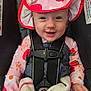 baby, child, car_seat, hat, strawberry, smile, blanket, clothing, safety_harness, cute, infant, person, seatbelt, apparel, headwear, young_child, happy, indoors, portrait, colorful
