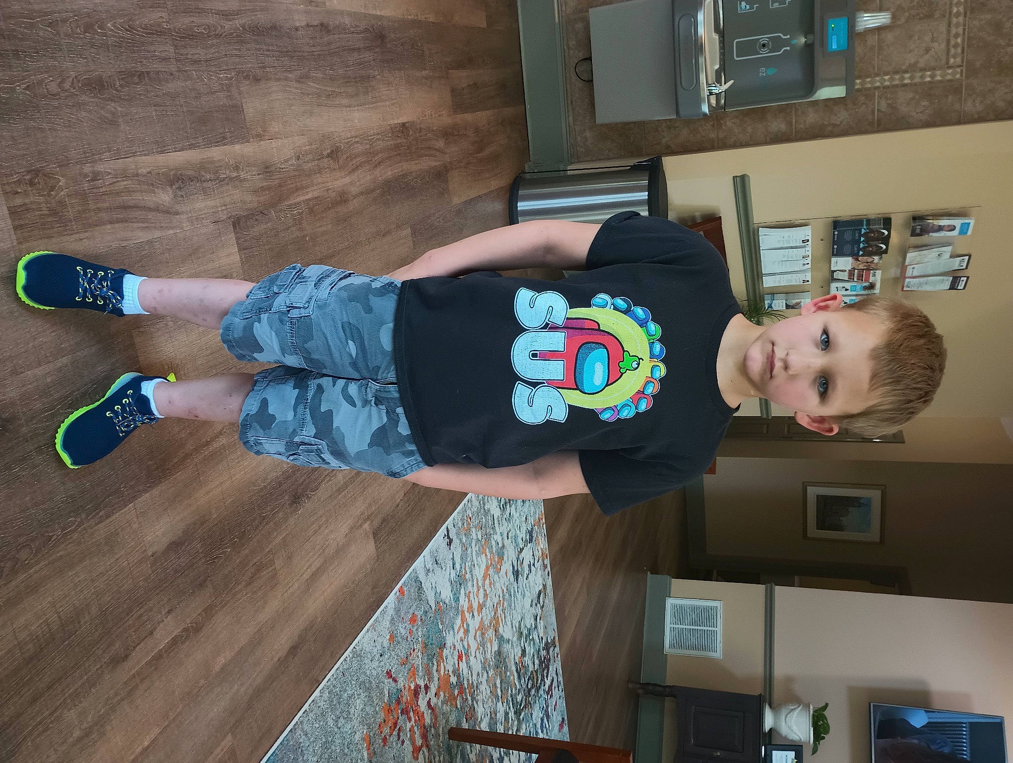 Dawson is registered to the contest to win money with this photo: child, denim, electric_blue, flooring, fun, hardwood, human_leg, person, picture_frame, room, shelf, shelving, sock, standing, t_shirt, textile, thigh, toddler, walking_shoe, wood