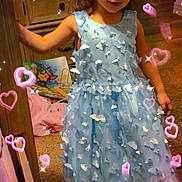 Jasmine is registered to the contest to win money with this photo: child, girl, dress, blue_dress, petals, sparkles, hearts, pink_hearts, carpet, room, furniture, cabinet, toy, book, barefoot, smiling, curly_hair, indoor, magic_effects, cute