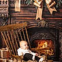 Elyo participe au concours pour gagner de l'argent avec cette photo : baby, child, rocking_chair, blanket, fireplace, fire, wood, holiday, christmas, decoration, pine_cones, ribbon, gift, present, floor, cozy, indoor, smiling, cute, portrait