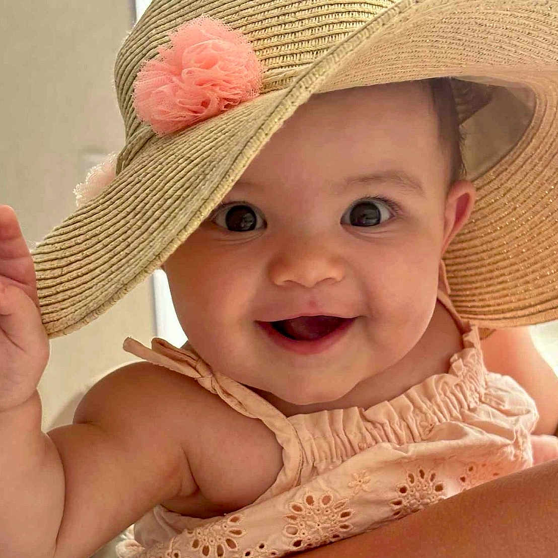 Lina participe au concours pour gagner de l'argent avec cette photo : baby, child, smile, hat, sunhat, flower, pink_flower, peach_dress, embroidery, cute, happy, portrait, closeup, face, waving, skin, cheerful, indoors, person, infant