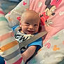 baby, smiling, infant, mickey_mouse, minnie_mouse, baby_seat, colorful, patterned, fabric, stripes, blue_shirt, safety_strap, cute, face, child, indoor, playful, happy, portrait, closeup