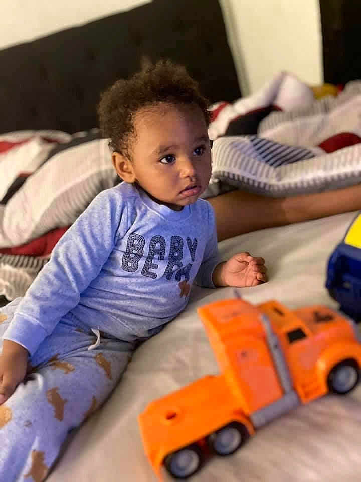Jayceon is registered to the contest to win money with this photo: baby, baby_playing_with_toys, baby_toddler_clothing, child, comfort, couch, face, flooring, fun, happy, head, leisure, person, riding_toy, skin, tire, toddler, toy, vehicle, wheel