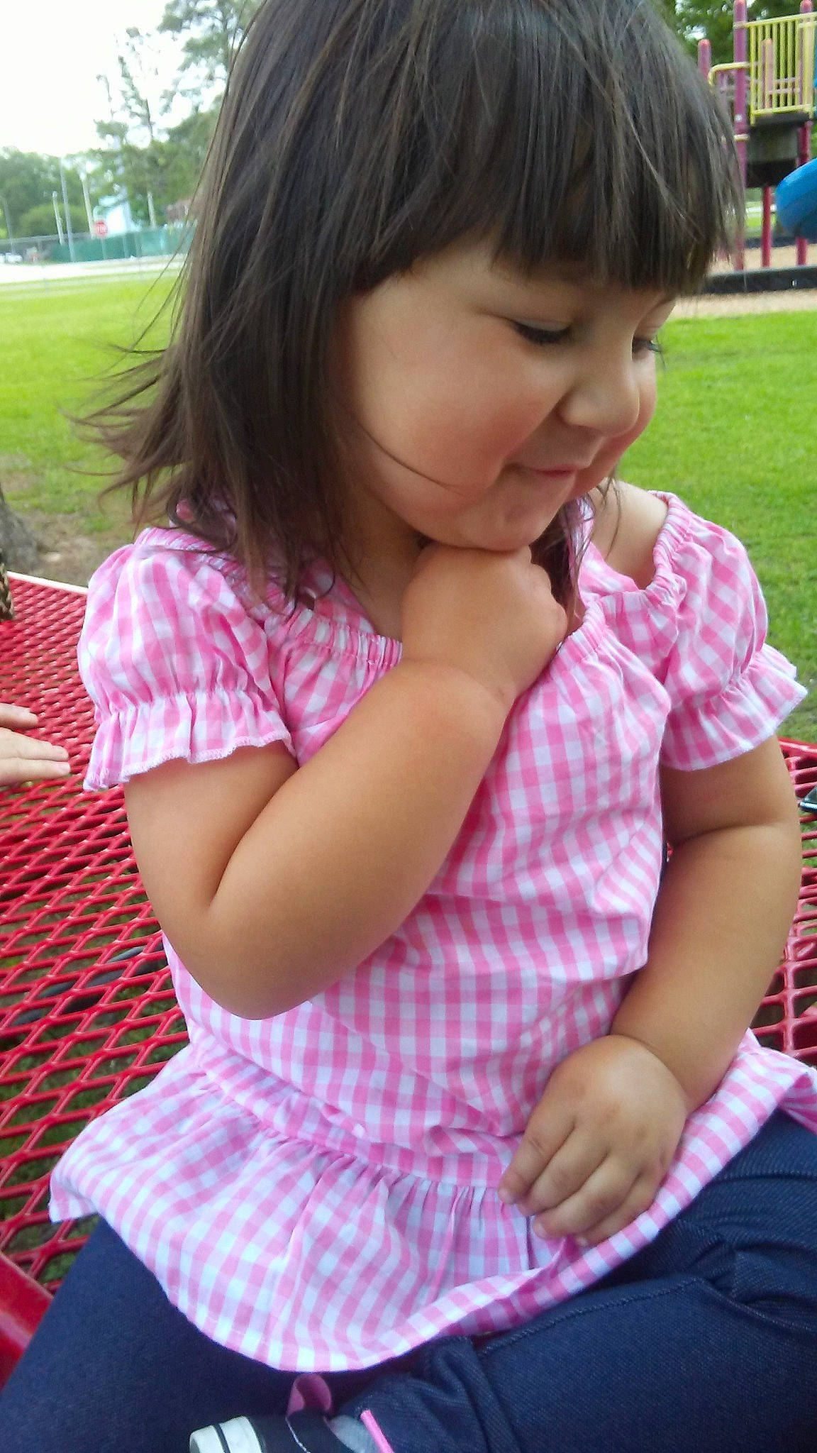 Leah is registered to the contest to win money with this photo: cheek, child, daughter, finger, grass, person, pink, play, recreation, sitting, skin, smile, toddler