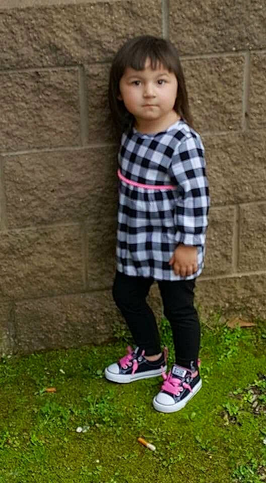 Leah is registered to the contest to win money with this photo: child, child_model, design, footwear, grass, leggings, outerwear, pattern, person, plaid, plant, play, shoe, sleeve, t_shirt, tartan, textile, tights, toddler