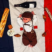 Loann participe au concours pour gagner de l'argent avec cette photo : baby, infant, flag, french_flag, bread, baguette, croissant, pastry, wine_bottle, milestone_card, 1_month, clothing, suspenders, hat, bow_tie, lying_down, portrait, food, celebration, cute
