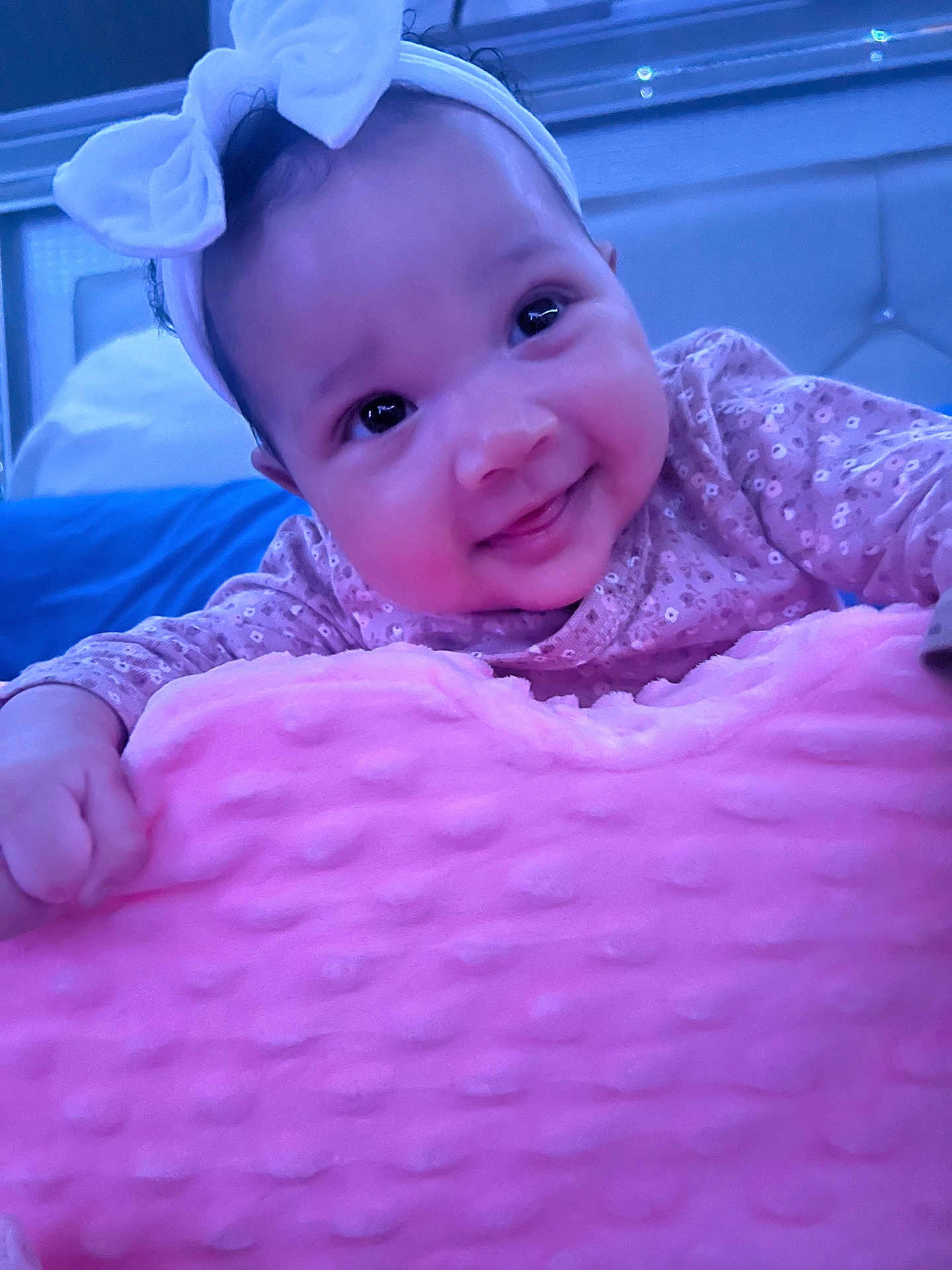 Monroe joined the competition — help win amazing prizes! baby, infant, headband, bow, pink_blanket, smile, big_eyes, close_up, portrait, lying_down, patterned_onesie, hand, plush_blanket, bedroom, soft_texture, adorable, cute, fabric, indoor, soft_lighting