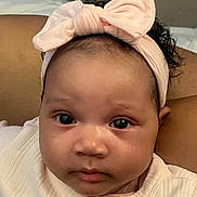 Monroe joined the competition — help win amazing prizes! baby, infant, headband, bow, face, eyes, cheeks, nose, mouth, skin, clothing, swaddle, portrait, closeup, indoor, bed, blanket, arm, newborn, gaze