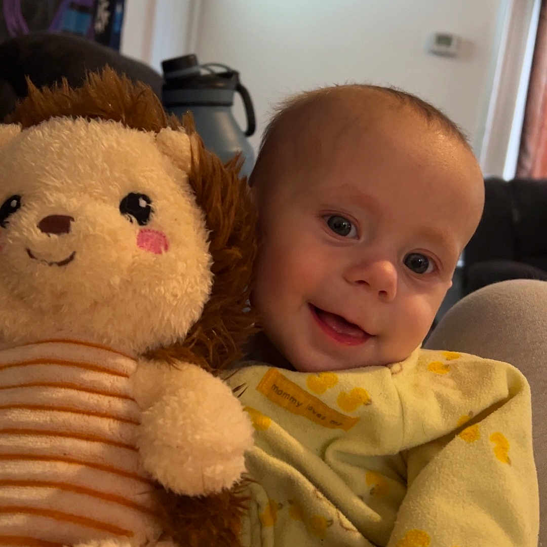 Robert is registered to the contest to win money with this photo: baby, blanket, bodypart, couch, cushion, face, finger, furniture, hand, head, homedecor, indoors, newborn, person, photography, plush, portrait, sitting, teddybear, toy