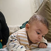 Araik a rejoint le concours — aidez-le/la à gagner de superbes lots ! baby, infant, child, face, portrait, clothing, bib, hand, skin, expression, indoors, cushion, blanket, person, soft, curious, young, cute, sleepwear, toddler