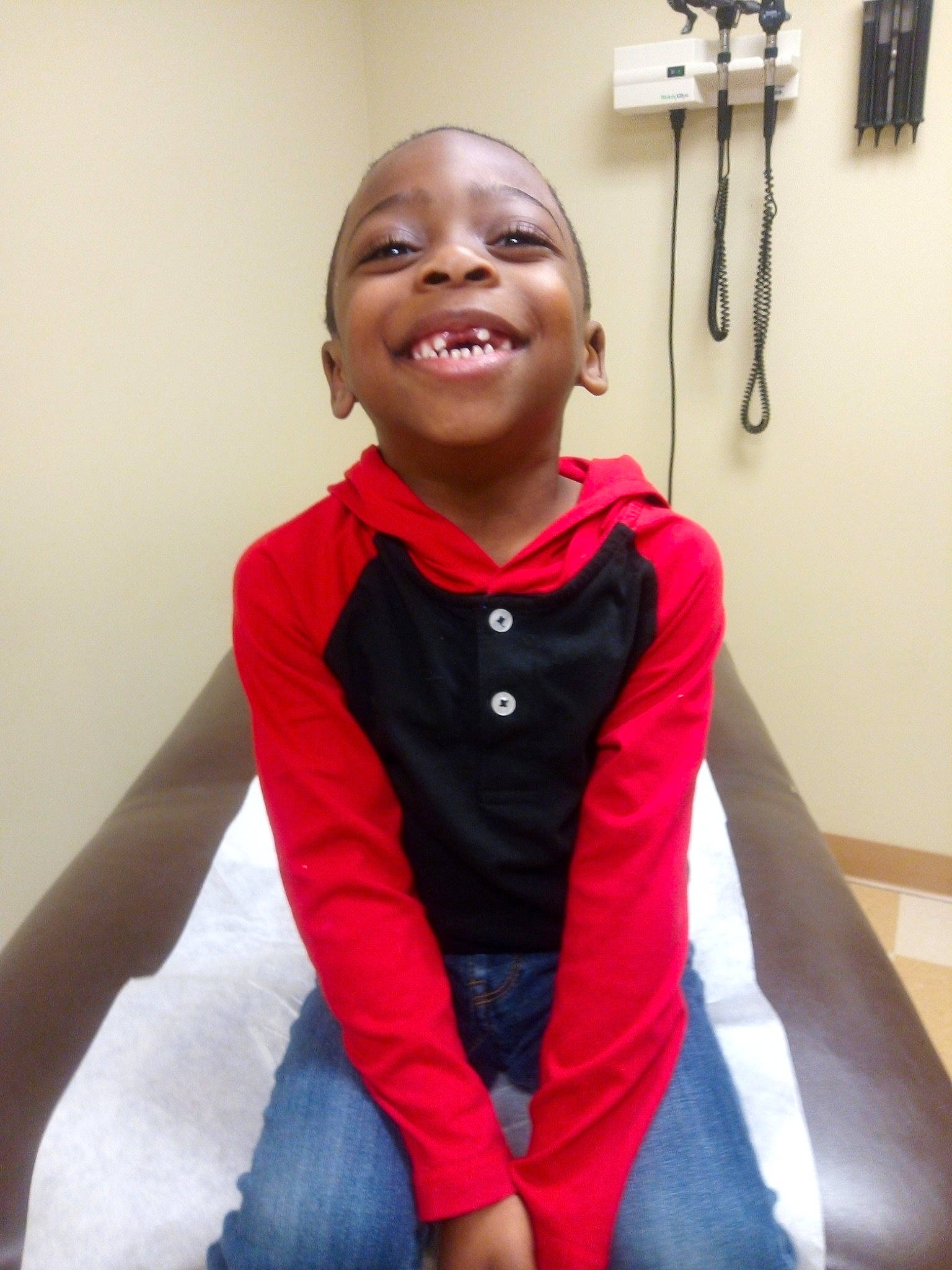 Jalil is registered to the contest to win money with this photo: arm, cheek, child, face, facial_expression, happy, headwear, joint, laugh, neck, outerwear, person, room, shoulder, sitting, smile, t_shirt, toddler, tooth