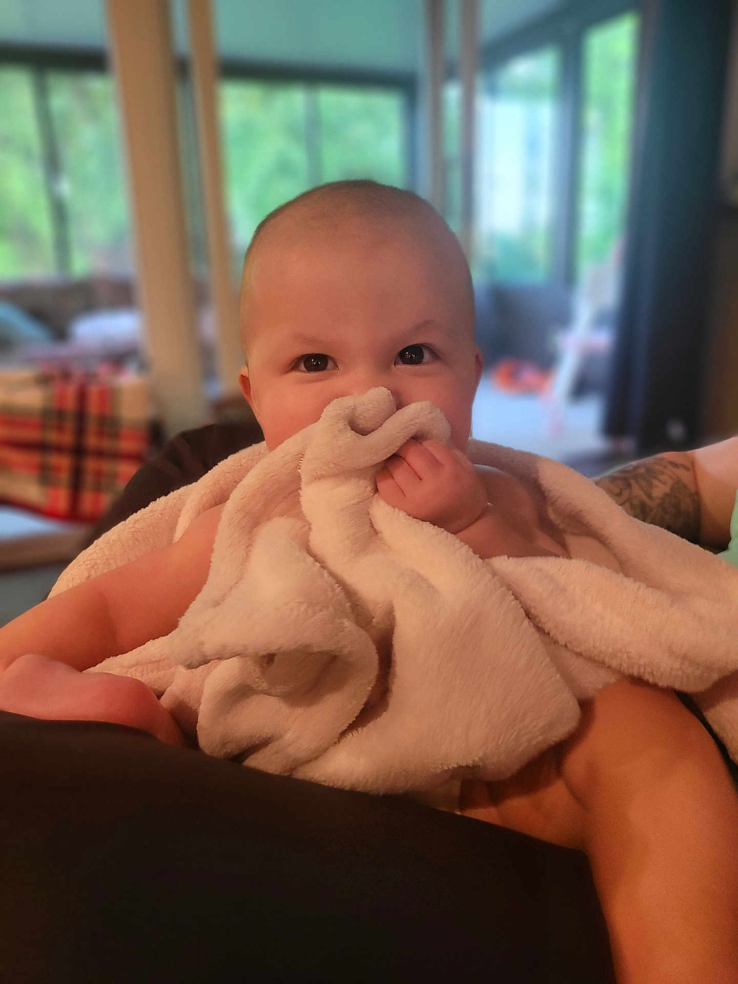 Willow joined the competition — help win amazing prizes! baby, blanket, infant, face, hand, skin, indoor, person, soft_texture, cuddle, cute, child, smile, happy, cozy, portrait, furniture, tattoo, blurred_background, family
