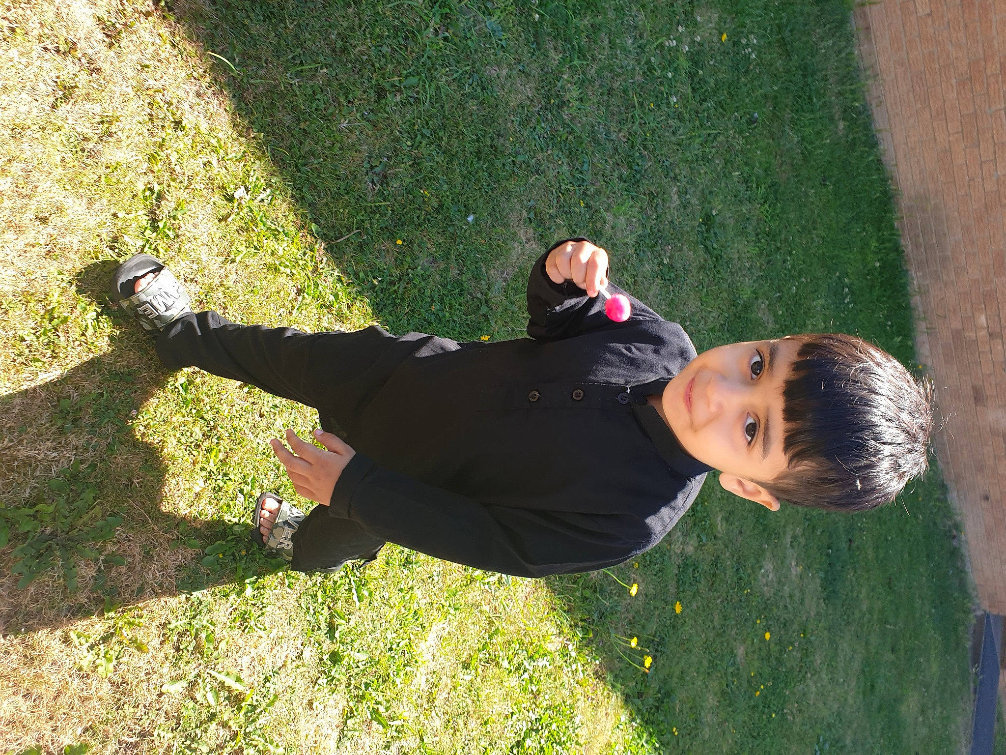 Hassan is registered to the contest to win money with this photo: artificial_turf, child, fun, grass, grass_family, grassland, happy, human_body, lawn, leisure, people_in_nature, person, plant, recreation, shadow, shrub, sitting, spring, toddler, tree