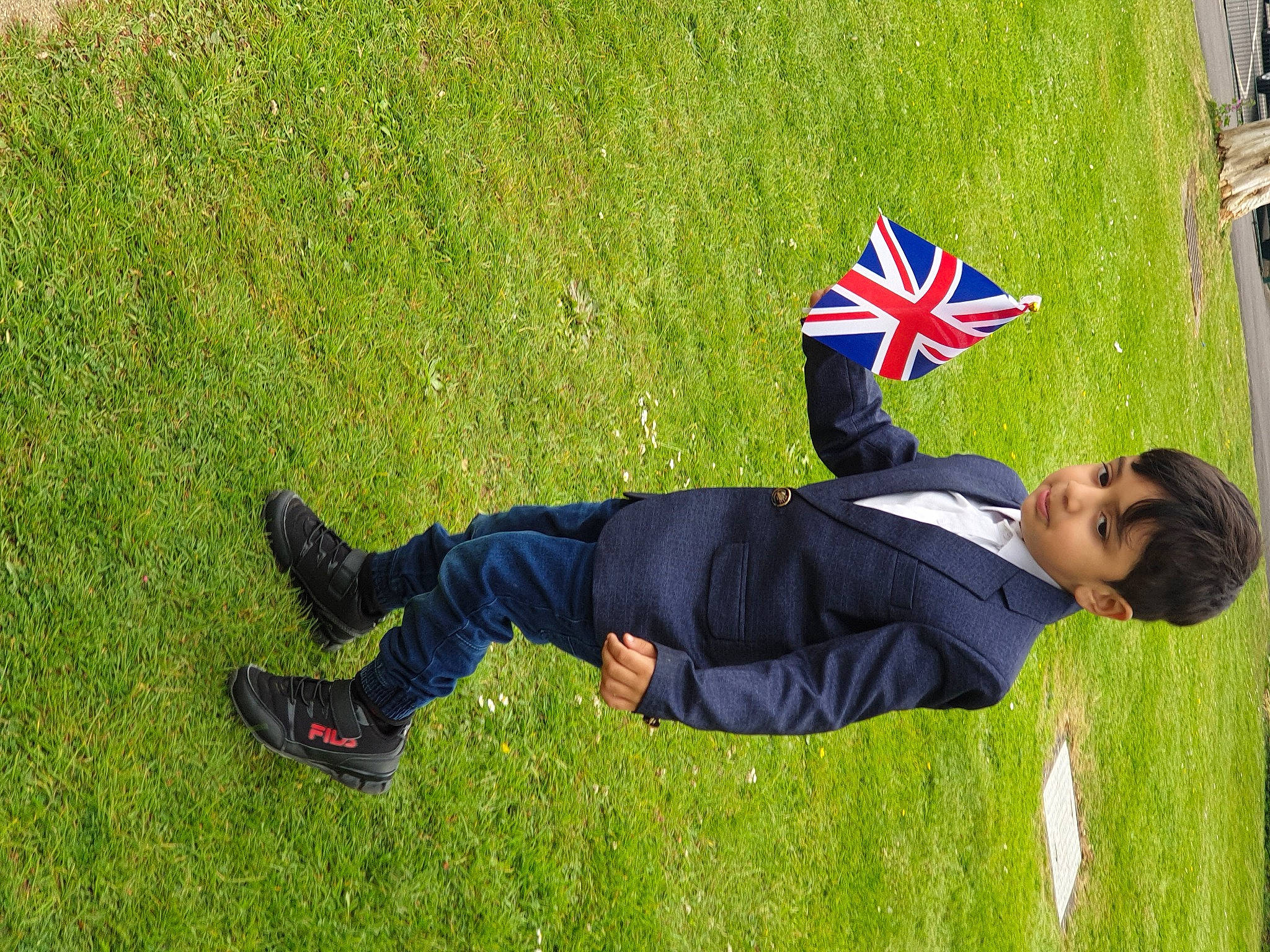 Hassan is registered to the contest to win money with this photo: artificial_turf, electric_blue, flag, fun, grass, grass_family, grassland, happy, knee, lawn, leisure, people_in_nature, person, plant, recreation, sitting