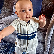 Bobby is registered to the contest to win money with this photo: baby, child, indoor, carpet, couch, velvet, furniture, clothing, socks, person, portrait, cute, standing, curious, home, blue, cream, knitwear, buttons, soft